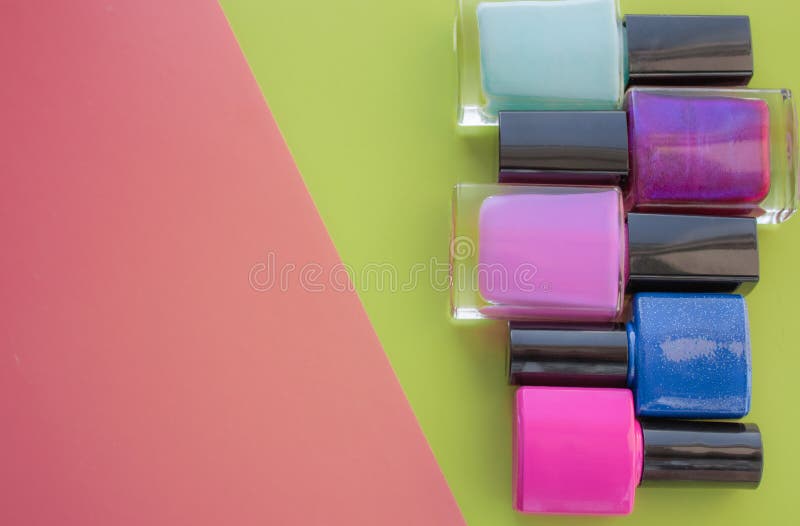 met le vernis à ongles en bouteille Un groupe de manucures lumineuses sur un rose, fond vert Avec l'espace vide du côté gauche photo libre de droits met le vernis à ongles en bouteille Un groupe de manucures lumineuses sur un rose, fond vert Avec l'espace vide du côté gauche photo libre de droits