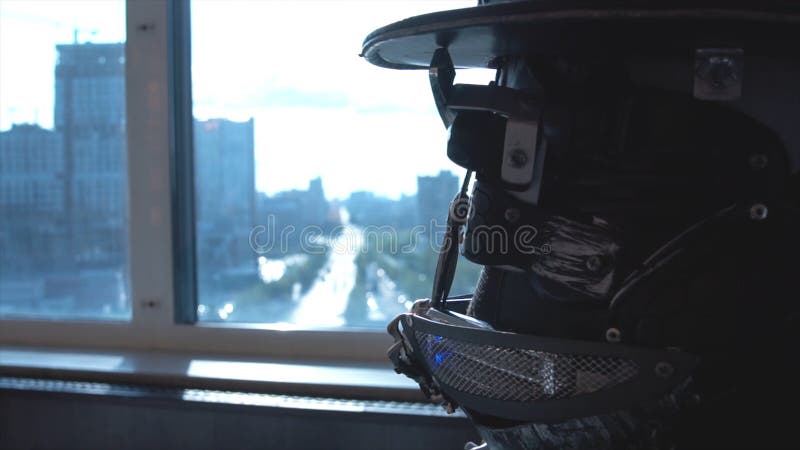 Metal android sitting at table in restaurant with glass of wine on background of view of high-rise buildings of city stock photo
