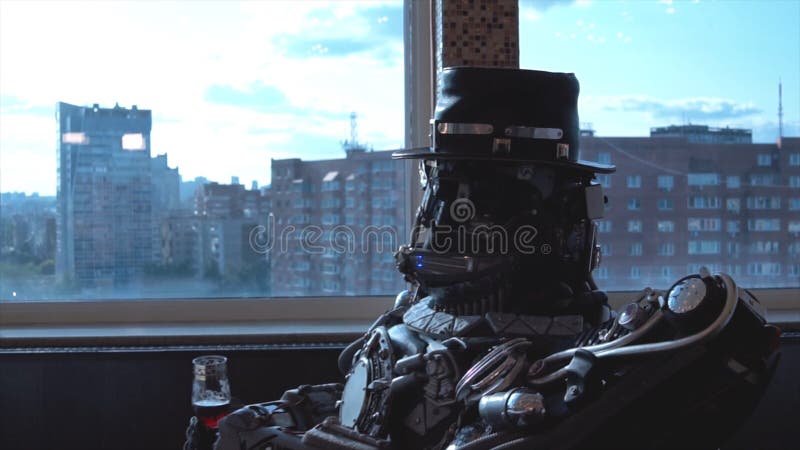 Metal android sitting at table in restaurant with glass of wine on background of view of high-rise buildings of city