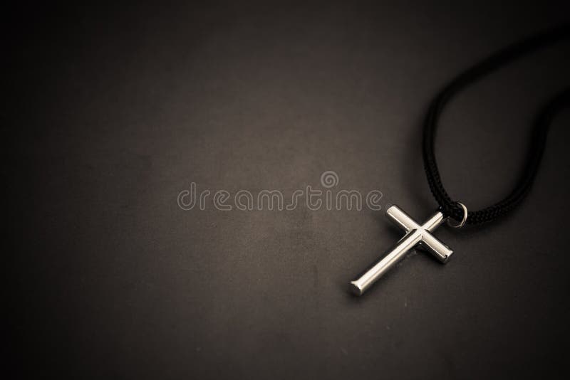 Metal cross on black table. religion concept.