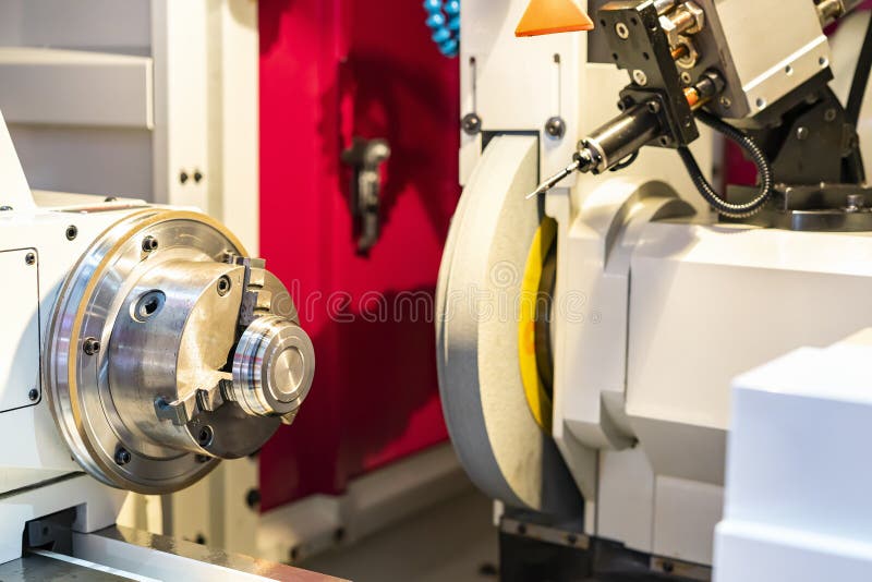 Metal cylinder or workpiece clamp by 3 jaw chuck and during surface grinding on high precision automatic cnc grinder machine with stock photo