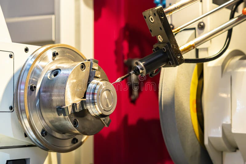 Metal cylinder or workpiece clamp by 3 jaw chuck and during surface grinding on high precision automatic cnc grinder machine with royalty free stock photo