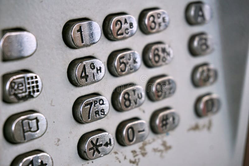 Metal el dial de teléfono en la cabina de teléfono público con las letras negras y los números en los botones plateados plata fotos de archivo Metal el dial de teléfono en la cabina de teléfono público con las letras negras y los números en los botones plateados plata fotos de archivo