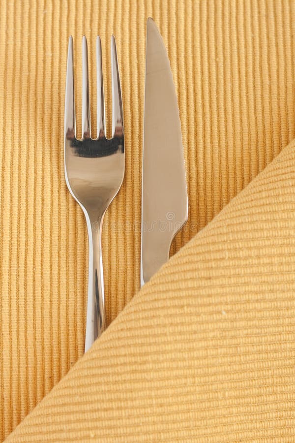 Metal fork and a knife lying on a tableclot