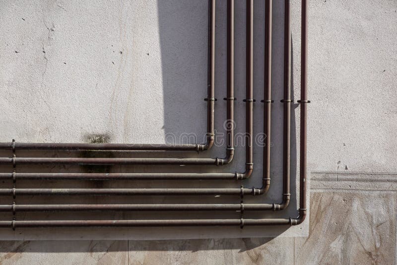 Metal gas pipe on in cement urban wall royalty free stock photo