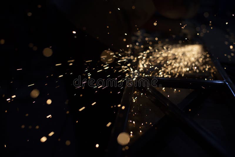 Metal Grinding. Sparks from Friction. Lights in Dark Stock Photo