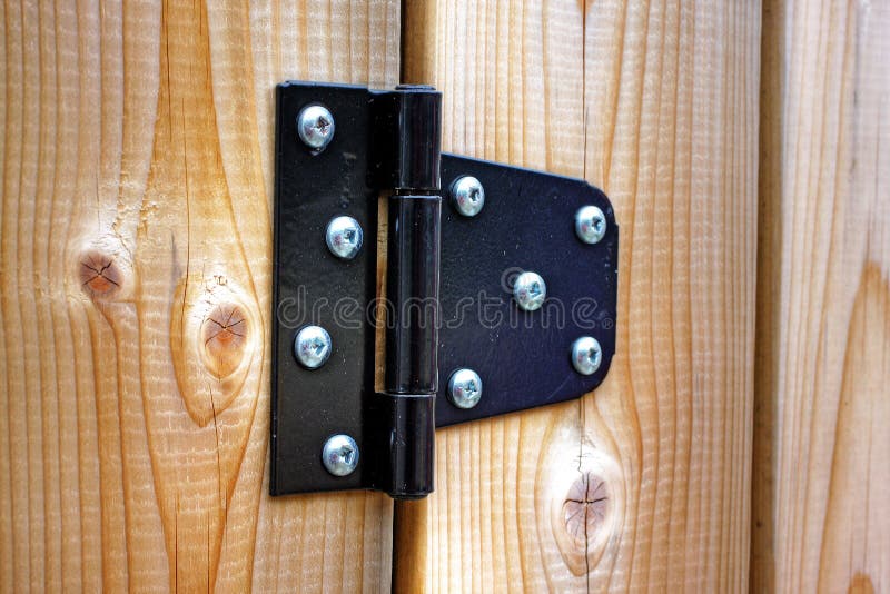 Metal hinge on polished wooden door. Metal hinge on polished wooden door
