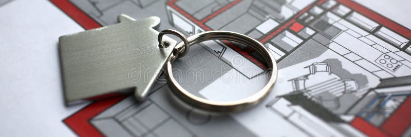Metal key chain in form miniature house lies on paper project of apartment concept closeup