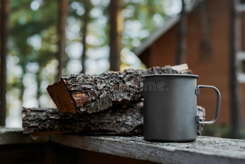 Metal la tazza nella natura accanto al legno
