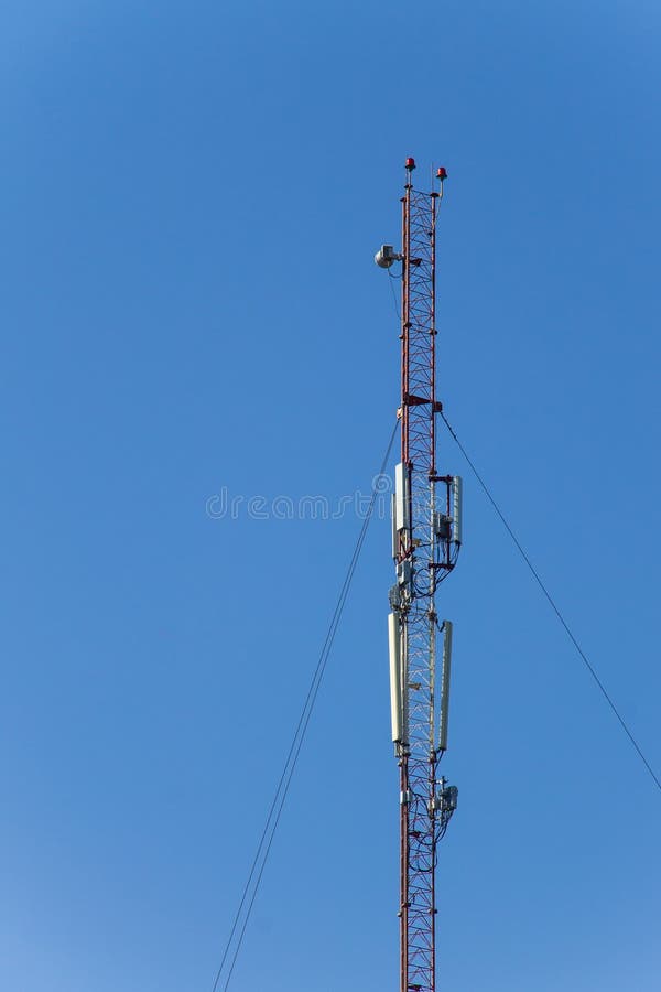 Metal la torre con las antenas para las comunicaciones m?viles del tel?fono celular contra el cielo azul imágenes de archivo libres de regalías Metal la torre con las antenas para las comunicaciones m?viles del tel?fono celular contra el cielo azul imágenes de archivo libres de regalías