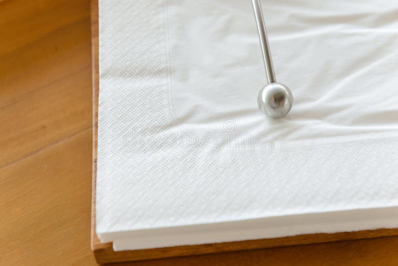 Metal Paperweight on Stack of White Square Paper Napkin. Modern Paper