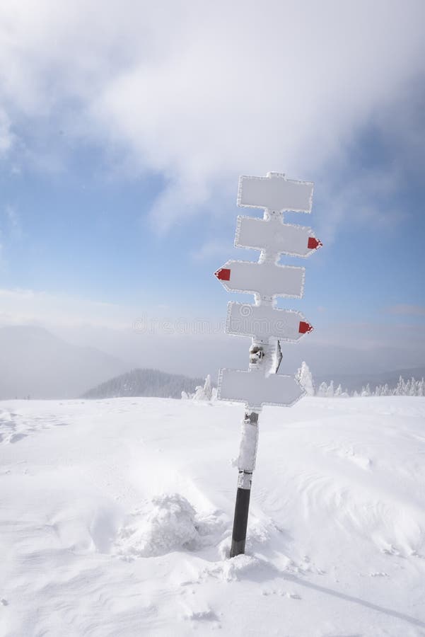 Metal pointer with arrows in winter mountains stock image Metal pointer with arrows in winter mountains stock image
