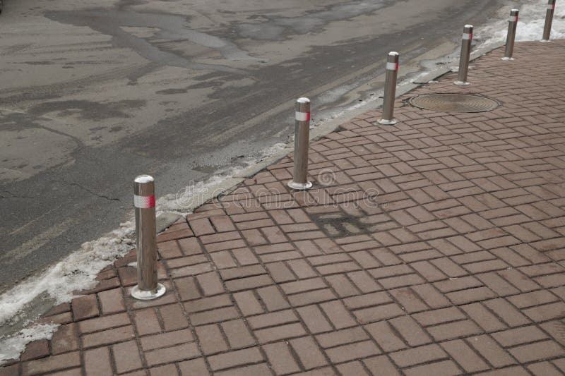 Metal posts separating the sidewalk and the road royalty free stock photo