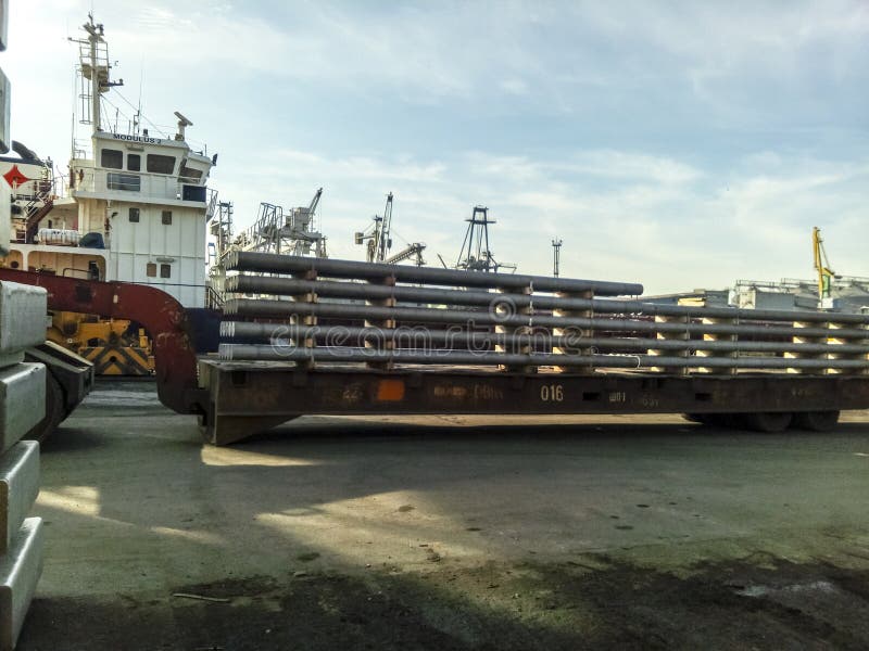 The metal rods folded on the port site for export. Temporary storage in the port of raw materials. Port cargo and cranes royalty free stock photo The metal rods folded on the port site for export. Temporary storage in the port of raw materials. Port cargo and cranes royalty free stock photo