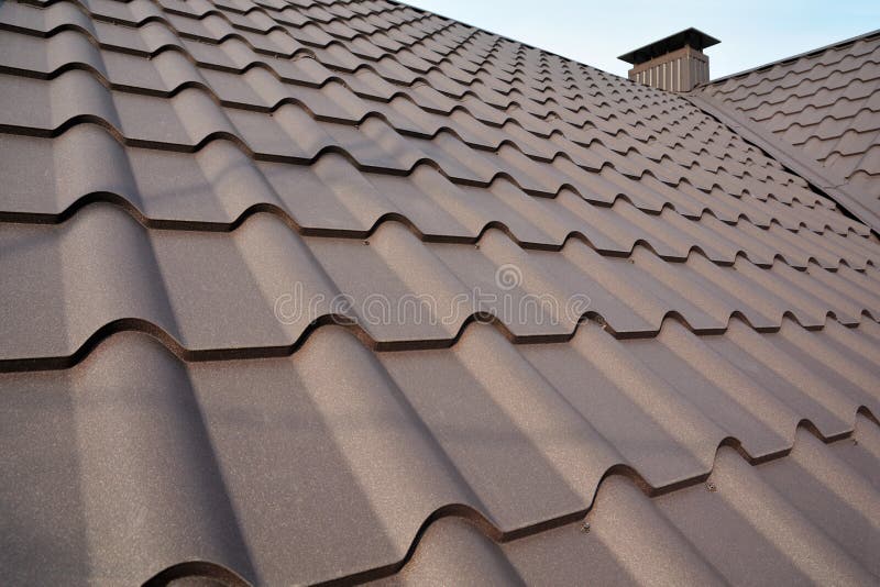 Metal Roof Construction Against Blue Sky. Roofing materials. Metal House roof. Closeup House Construction Building Materials.