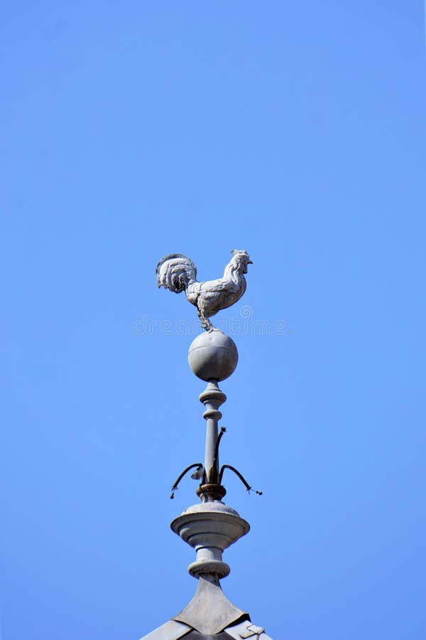 Metal rooster icon at pinnacle of building spire