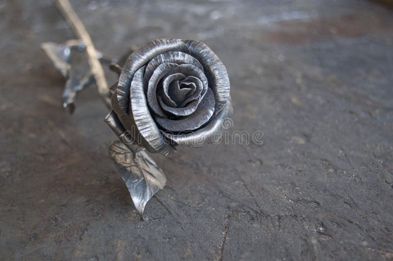 Metal rose on shabby wooden background