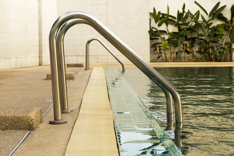 Metal staircase in school swimming pool with sunny reflections stock photo Metal staircase in school swimming pool with sunny reflections stock photo
