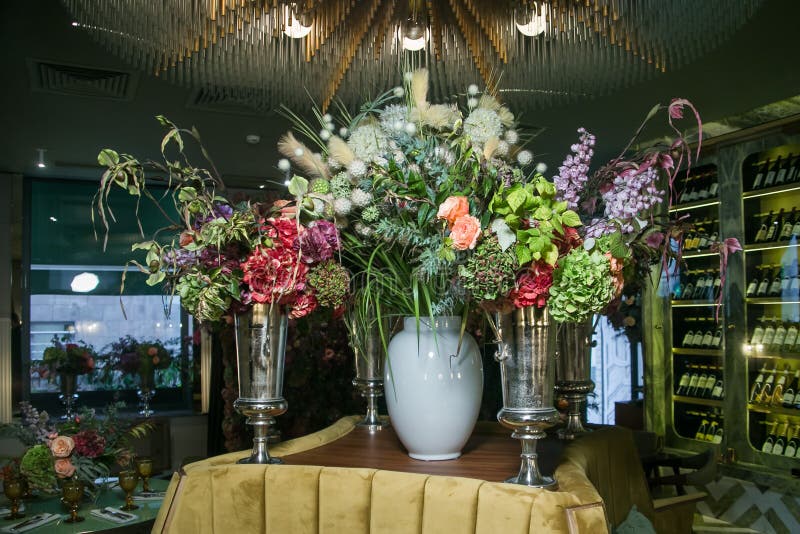 Metal Vases in the Form of a Goblet with Bouquets of Flowers are on the