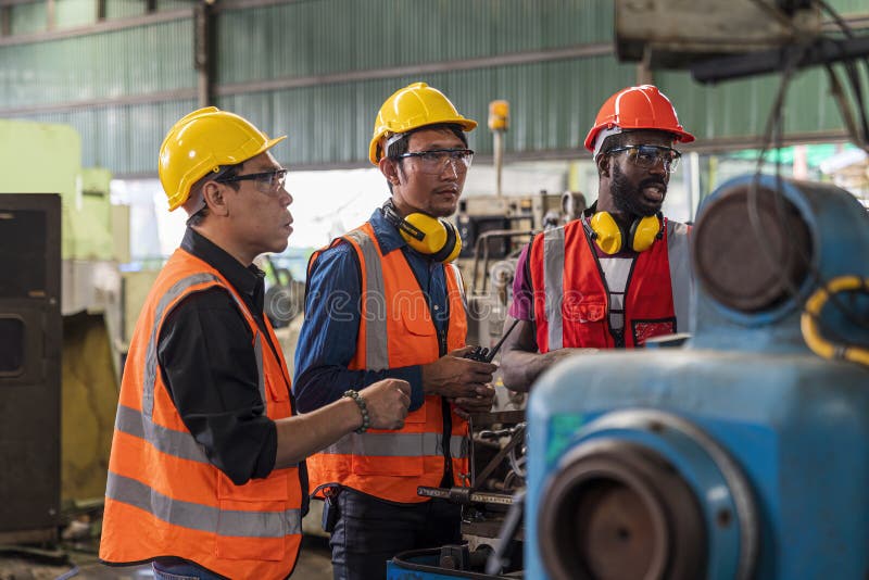 Metal Worker Teaching Trainee on Machine. Engineer Men Wearing Uniform