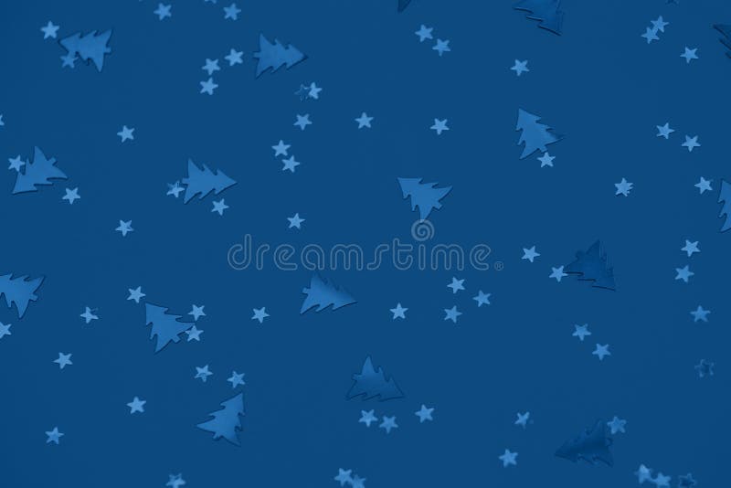 Metallic foil christmas trees and stars confetti sparse on trendy blue background