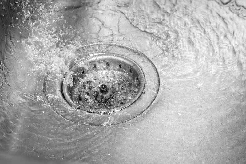 Metallic kitchen sink drain swirly water flow