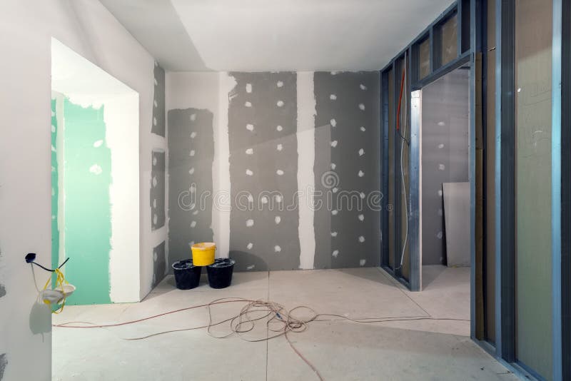 Metallrahmen und Fasergipsplattentrockenmauer für Gipswände, drei Eimer und elektrische Drähte in der Wohnung ist im Bau