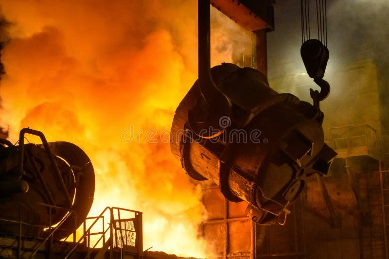 A metallurgical ladle filled with molten metal bucket is suspended on a special crane beam