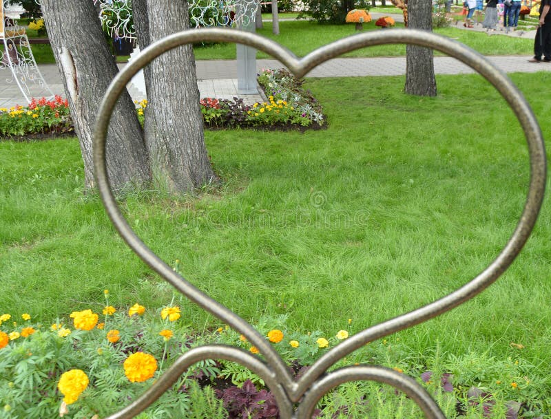 Metalu deseniowy kierowy symbol, spojrzenie przez serca na trawie, park, Valentine& x27; s dzień fotografia royalty free Metalu deseniowy kierowy symbol, spojrzenie przez serca na trawie, park, Valentine& x27; s dzień fotografia royalty free