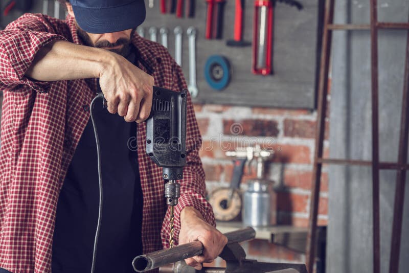 Metalworker Drilling a Hole in a Metal Pipe Stock Photo Image of