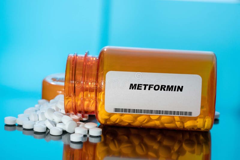 Metformin white medical pills and tablets spilling out of a drug bottle. Macro top down view with copy space