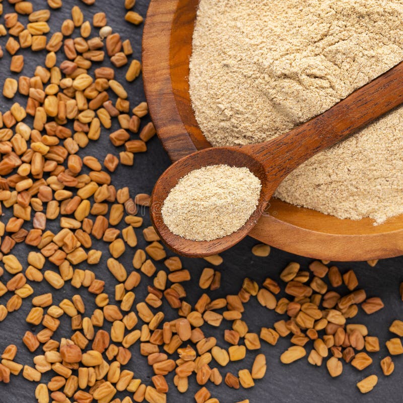 Methi Dana - Crushed dried fenugreek seeds in a bowl and spoon royalty free stock photos