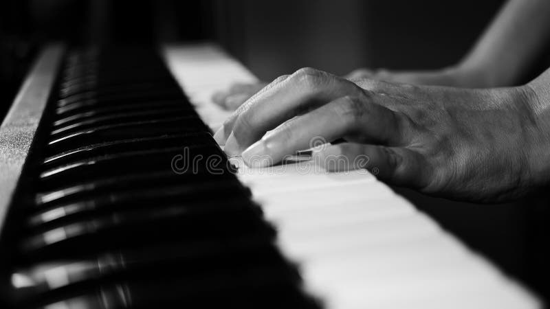 metragem 4K das mãos do pianista da música do piano que jogam a cor preto e branco monocromática foco seletivo do piano de cauda