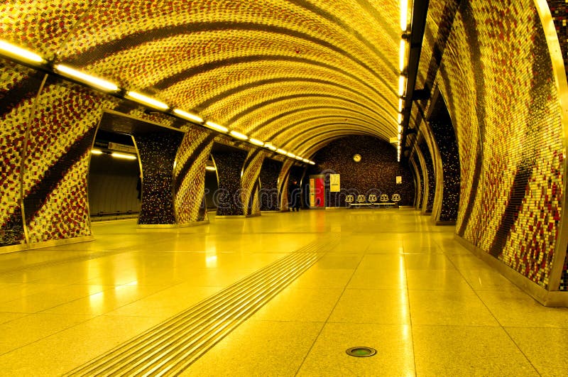 Metro station in Budapest, Hungary. Bright yellow ceramic mosaic tile wall finish with spiral pattern