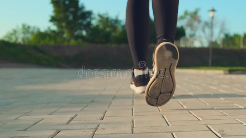 Metros de la mujer en las zapatillas corren sobre tiro del ángulo de la plaza de la ciudad metrajes