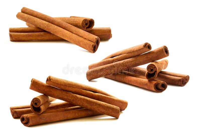 Metta dei bastoni di cannella sui precedenti bianchi immagine stock Metta dei bastoni di cannella sui precedenti bianchi immagine stock
