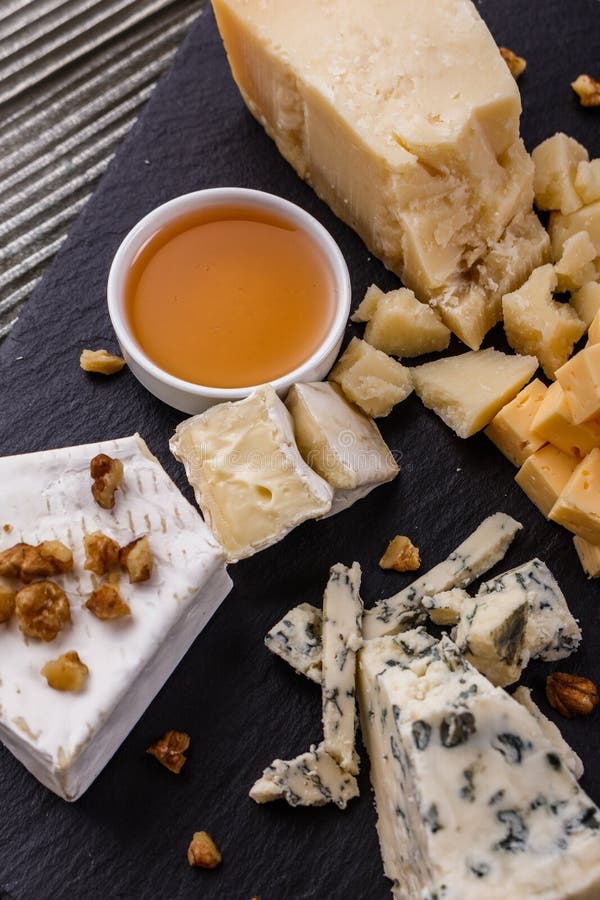 Metta dei formaggi differenti su un fondo rustico di legno immagini stock libere da diritti