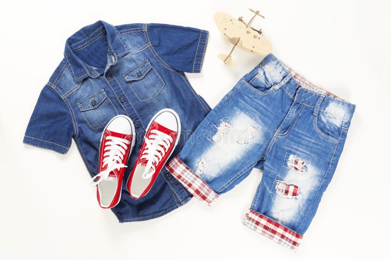 Metta dei vestiti alla moda del denim, collage d'avanguardia dei vestiti di modo dei bambini sulla disposizione bianca e piana, v fotografia stock Metta dei vestiti alla moda del denim, collage d'avanguardia dei vestiti di modo dei bambini sulla disposizione bianca e piana, v fotografia stock