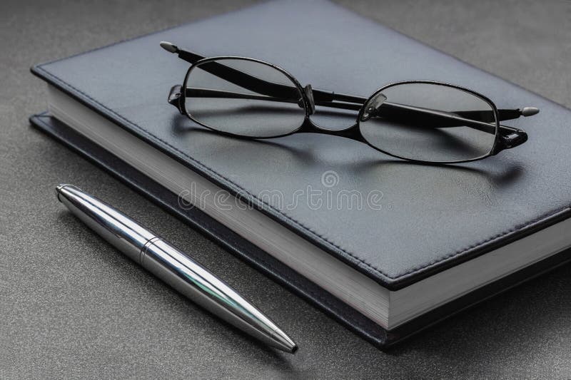 Mettez les verres et le stylo sur un carnet image stock Mettez les verres et le stylo sur un carnet image stock