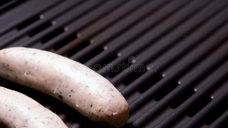 Mettre des saucisses sur le gril électrique fermer la vidéo 4k résolution. délicieux plat de viande grillée rôtie frite prêt pour banque de vidéos