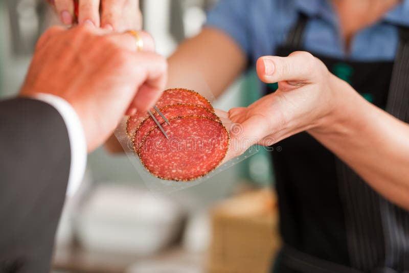 Metzger, der dem Abnehmer Frischfleisch-Steaks zeigt lizenzfreie stockfotografie Metzger, der dem Abnehmer Frischfleisch-Steaks zeigt lizenzfreie stockfotografie