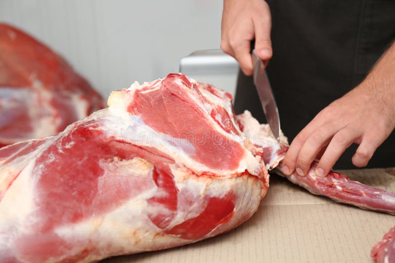 Metzger, der frisches rohes Fleisch auf Zähler im Geschäft schneidet stockfotografie Metzger, der frisches rohes Fleisch auf Zähler im Geschäft schneidet stockfotografie