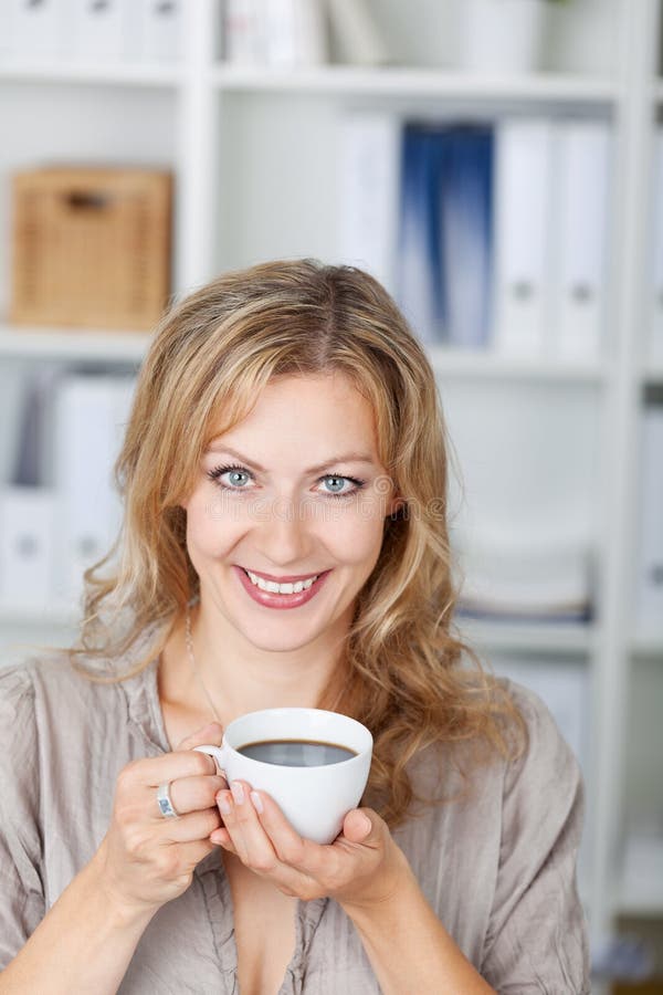Metà di donna di affari adulta Holding Coffee Cup in ufficio immagine stock libera da diritti Metà di donna di affari adulta Holding Coffee Cup in ufficio immagine stock libera da diritti