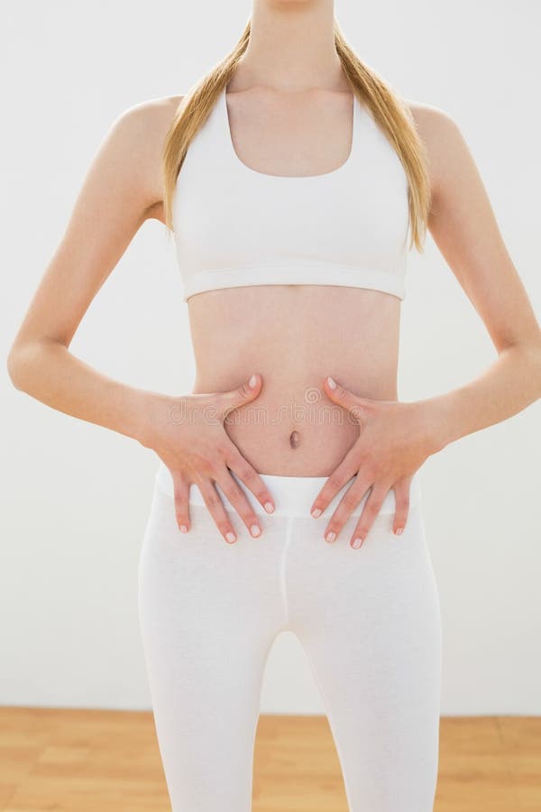 Metà di sezione della donna bionda snella che tocca la sua pancia fotografie stock libere da diritti Metà di sezione della donna bionda snella che tocca la sua pancia fotografie stock libere da diritti