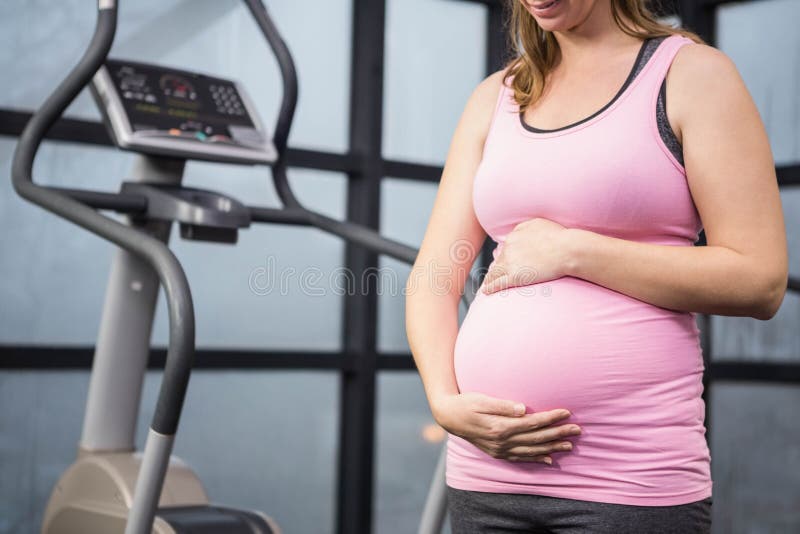 Metà di sezione della donna incinta che tocca la sua pancia fotografia stock libera da diritti Metà di sezione della donna incinta che tocca la sua pancia fotografia stock libera da diritti