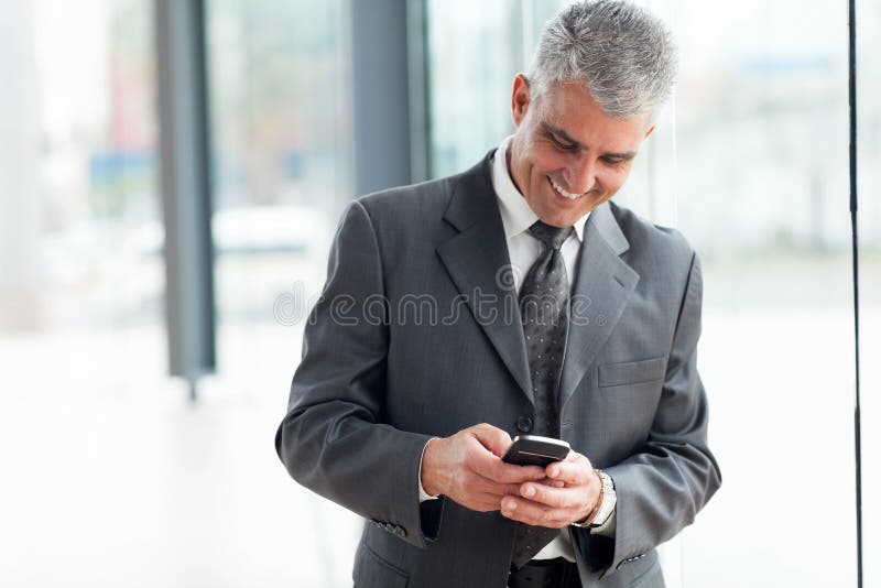 Uomo d'affari di mezza età con smartphone immagini stock