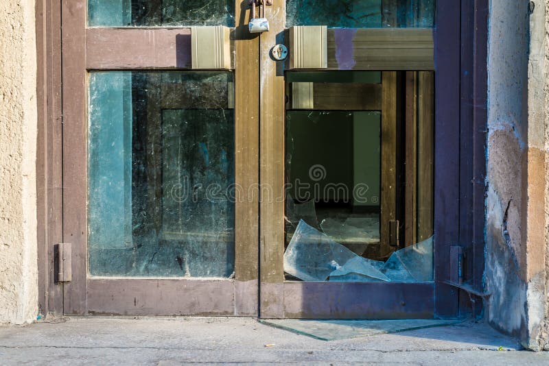 Metà di vecchia porta di vetro rotta con la serratura d'acciaio fotografia stock Metà di vecchia porta di vetro rotta con la serratura d'acciaio fotografia stock