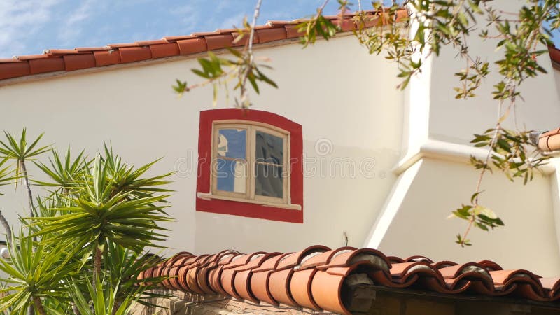 Mexican colonial style suburban, hispanic house exterior, green lush garden, San Diego, California USA. Mediterranean terracotta ceramic clay tile on roof. Rustic spanish tiled rooftop. Rural details. Mexican colonial style suburban, hispanic house exterior, green lush garden, San Diego, California USA. Mediterranean terracotta ceramic clay tile on roof. Rustic spanish tiled rooftop. Rural details