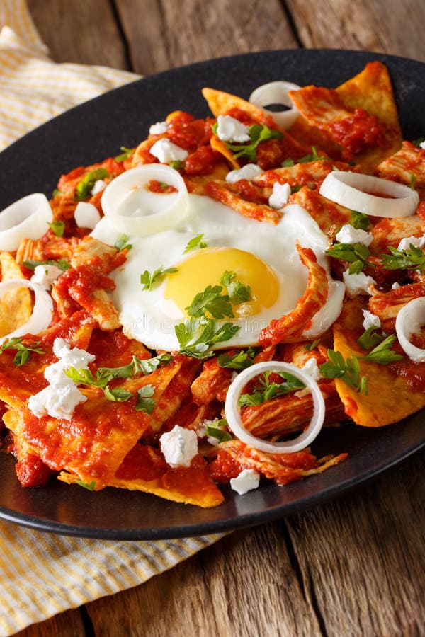 Mexican Breakfast: Chilaquiles with Egg and Chicken Close-up. Vertical ...