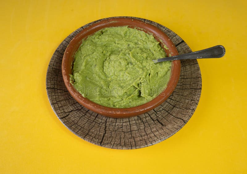 Mexican delicious guacamole on a yellow background royalty free stock photos